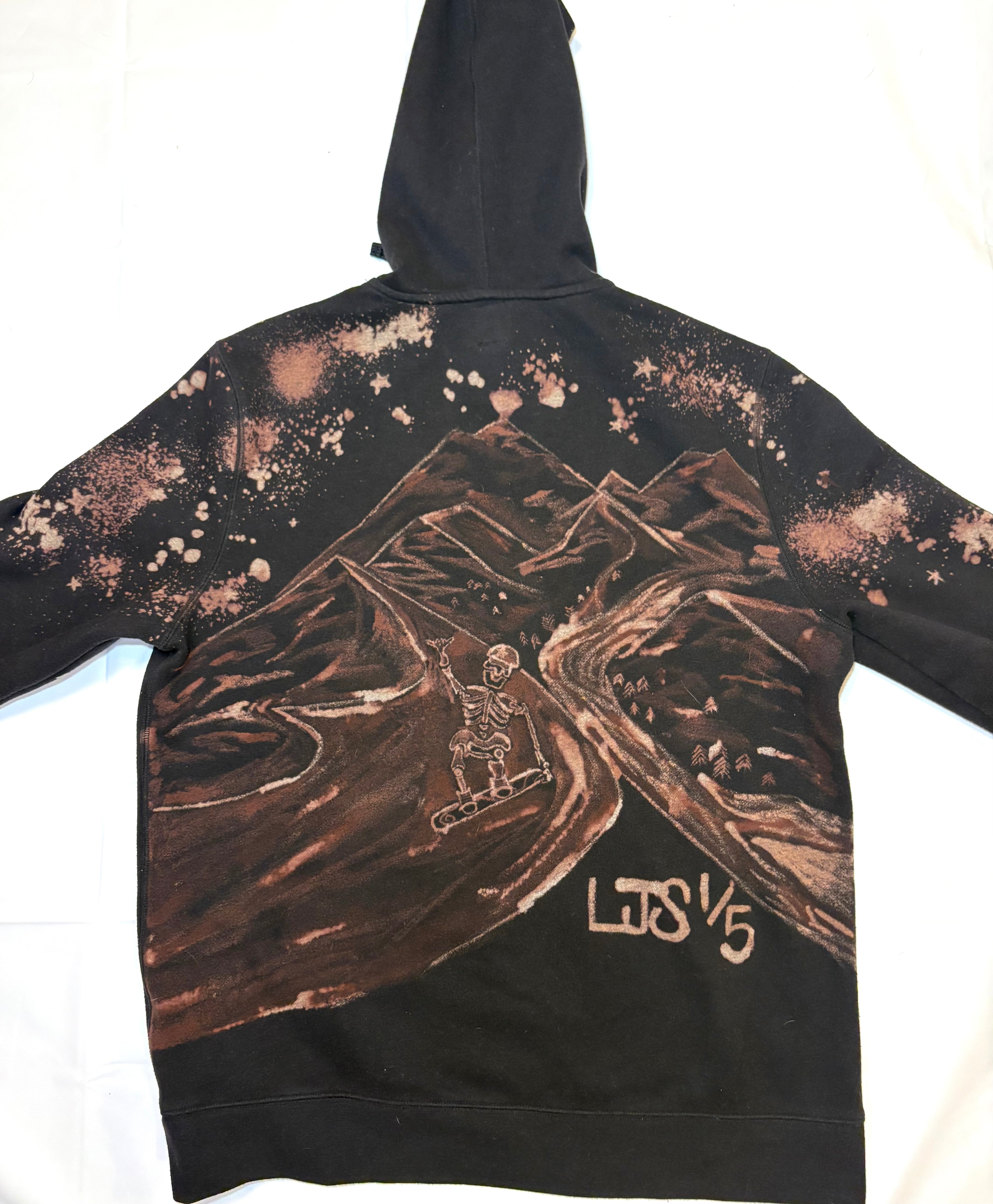 Black hoodie hand painted bleach art skeleton snow border hitting a big jump 