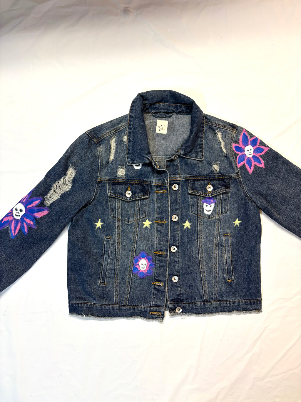 Denim jacket with floral and skull designs on a white background hand painted 