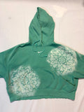 Green hoodie with mandala design on a white background