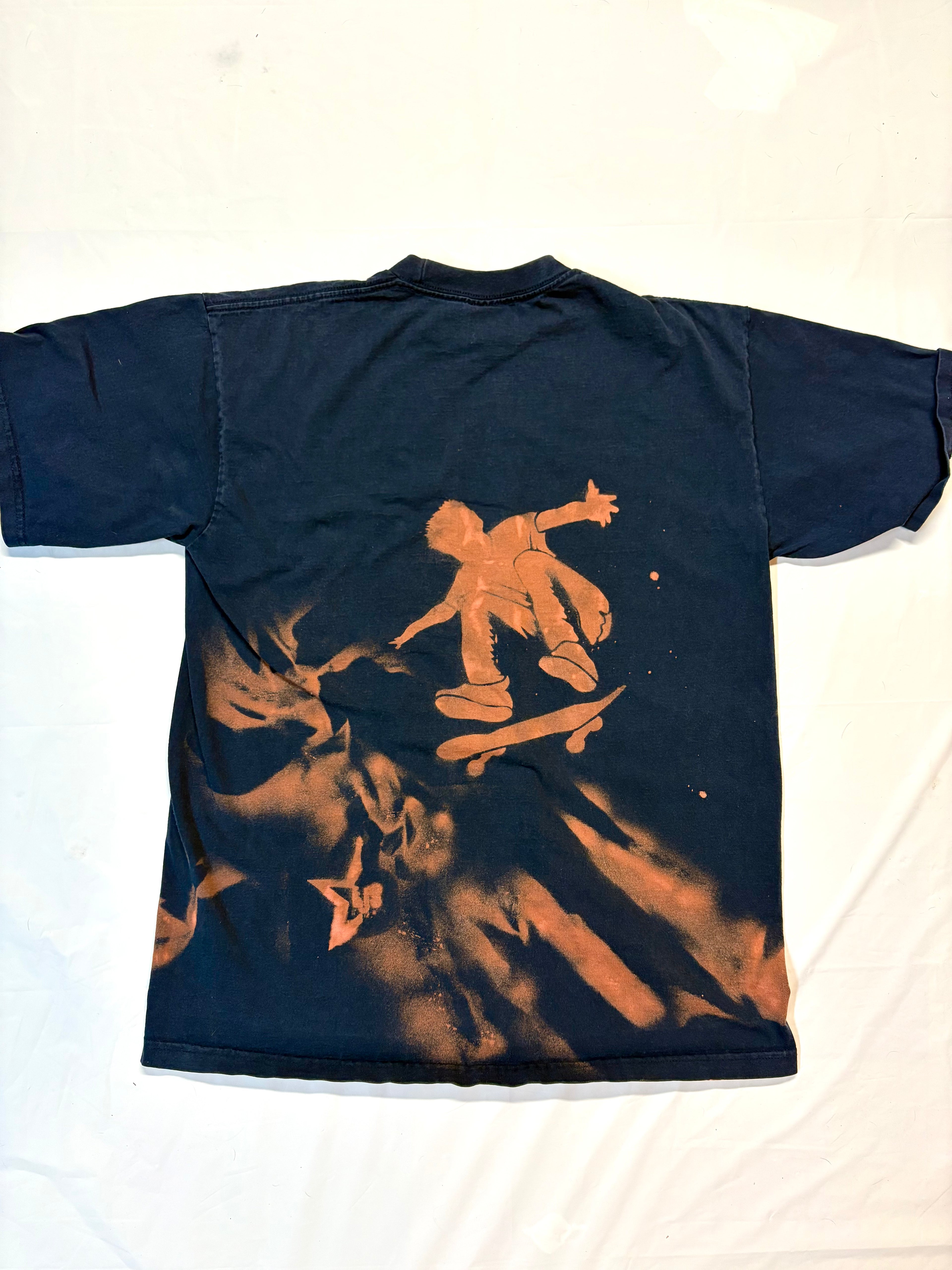 Navy blue t shirt with bleach art skater doing a trick 